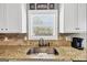 Kitchen sink featuring a window, granite counters, and stylish backsplash at 10736 Southwood Dr, Hampton, GA 30228