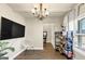 Comfortable living room showcases a large TV, chandelier, and a cozy seating area with ample light at 10736 Southwood Dr, Hampton, GA 30228