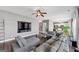 Bright and airy living room features a large sectional sofa and large-screen television at 10736 Southwood Dr, Hampton, GA 30228
