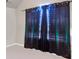 A window with a dark curtain that has string lights on it in an empty room at 10736 Southwood Dr, Hampton, GA 30228