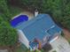 Aerial view of a brick home with a beautiful pool and lush green surroundings at 500 Merrill Ln, Peachtree City, GA 30269
