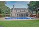 An in-ground pool is surrounded by a concrete patio and green lawn at 500 Merrill Ln, Peachtree City, GA 30269