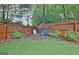 Fenced in yard with a small fire pit and wood pile surrounded by shrubs and greenery at 500 Merrill Ln, Peachtree City, GA 30269