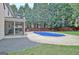 Inviting backyard with swimming pool, screen porch, trees, fence and green grass at 500 Merrill Ln, Peachtree City, GA 30269