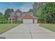 Charming two-story brick home with a well-manicured lawn and long driveway at 500 Merrill Ln, Peachtree City, GA 30269