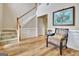 Bright foyer with staircase, elegant chair, hardwood floors, and artwork creating a welcoming entrance at 500 Merrill Ln, Peachtree City, GA 30269