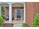 Inviting front porch with brick columns, bench, and a welcoming door at 500 Merrill Ln, Peachtree City, GA 30269