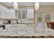 Beautiful kitchen with white cabinets, granite countertops, and modern pendant lighting fixtures at 500 Merrill Ln, Peachtree City, GA 30269