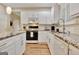 Kitchen featuring granite countertops, white cabinets, and stainless steel appliances at 500 Merrill Ln, Peachtree City, GA 30269