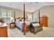 Spacious main bedroom with a four-poster bed, bench, dresser, and plenty of natural light from windows at 500 Merrill Ln, Peachtree City, GA 30269