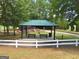 Picnic tables and charcoal grills under a park pavilion near a playground and walking trail at 500 Merrill Ln, Peachtree City, GA 30269