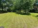 Large backyard with lush green grass, mature trees, and ample space for outdoor activities at 3551 Skyline Sw Ter, Marietta, GA 30008