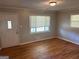 Hardwood floors, white trim, fresh paint, and a large window highlight this living room at 3551 Skyline Sw Ter, Marietta, GA 30008