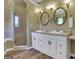Bathroom with a glass shower, & sinks, and updated lighting fixtures at 940 Planters Pl, Loganville, GA 30052