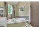 Corner bath featuring a separate shower and soaking tub with tiled backsplash at 940 Planters Pl, Loganville, GA 30052
