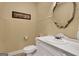 Cozy half-bath with cream-colored walls, decorative mirror, and white vanity at 940 Planters Pl, Loganville, GA 30052