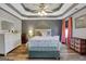 Bright bedroom featuring a trey ceiling, hardwood floors, and soft, natural light at 940 Planters Pl, Loganville, GA 30052