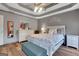 Relaxing bedroom featuring a trey ceiling, hard floors, and soft, natural light at 940 Planters Pl, Loganville, GA 30052