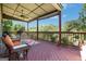 Charming covered deck featuring outdoor seating, colorful rug, and views of the lush greenery at 940 Planters Pl, Loganville, GA 30052