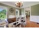 Dining room featuring wood floors, white wainscoting, and a decorative chandelier at 940 Planters Pl, Loganville, GA 30052