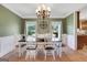 Charming dining room featuring a chandelier, sage green walls, and white wainscoting at 940 Planters Pl, Loganville, GA 30052