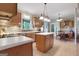 Well-lit kitchen with an island, wooden cabinets, and tiled flooring at 940 Planters Pl, Loganville, GA 30052