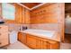 Large tub with wood accents, tile flooring, wood paneled walls, and a window with natural light at 258 Big Oak Rd, Whitesburg, GA 30185