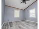 This bedroom features durable gray flooring, a ceiling fan, and natural light from the windows at 258 Big Oak Rd, Whitesburg, GA 30185