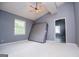 Bedroom featuring modern gray walls, bright light, ceiling fan, and additional room access at 258 Big Oak Rd, Whitesburg, GA 30185