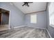 This bedroom features durable gray flooring, a ceiling fan, and natural light from the window at 258 Big Oak Rd, Whitesburg, GA 30185