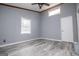 This bedroom features durable gray flooring, a ceiling fan, and natural light from the windows at 258 Big Oak Rd, Whitesburg, GA 30185