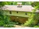 View of the back exterior of the house with brick foundation and trees at 258 Big Oak Rd, Whitesburg, GA 30185