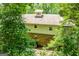 View of the back exterior of the house with brick foundation and trees at 258 Big Oak Rd, Whitesburg, GA 30185