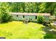 Exterior view of the mobile home surrounded by an extensive lawn and trees at 258 Big Oak Rd, Whitesburg, GA 30185