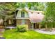 Brick house featuring a gambrel roof, covered porch, and lush garden landscape for a perfect blend of charm and nature at 258 Big Oak Rd, Whitesburg, GA 30185