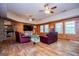 Spacious living room boasts wood paneling, hardwood floors, fireplace, and two ceiling fans at 258 Big Oak Rd, Whitesburg, GA 30185