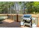 Wooden deck with a built-in grill and a view of the wooded backyard at 165 Longshore Way, Fayetteville, GA 30215