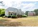 Side view of a two-story home featuring a spacious backyard, deck, and well-maintained landscaping at 165 Longshore Way, Fayetteville, GA 30215