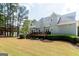 The side of a two-story house with a deck and a large backyard with tall mature trees at 165 Longshore Way, Fayetteville, GA 30215