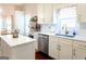 Well-lit kitchen featuring an island, quartz countertops, and stainless steel appliances at 165 Longshore Way, Fayetteville, GA 30215