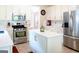 Bright kitchen features stainless steel appliances, white cabinetry, and a large center island at 165 Longshore Way, Fayetteville, GA 30215