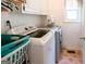 Functional laundry room with a washing machine, dryer, and storage space at 165 Longshore Way, Fayetteville, GA 30215