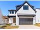 Striking modern home featuring a white brick facade, black trim, and attached garage at 1240 Hayes Sq, Peachtree City, GA 30269