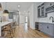 Open kitchen design with seating, gray cabinets, wine fridge, and stainless steel appliances at 1240 Hayes Sq, Peachtree City, GA 30269