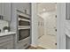 Elegant kitchen with built-in ovens, gray cabinets, and pantry access at 1240 Hayes Sq, Peachtree City, GA 30269