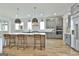 Bright kitchen with a large island, bar stool seating, gray cabinets, and modern appliances at 1240 Hayes Sq, Peachtree City, GA 30269
