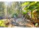 Landscaped patio with wooden fence, chairs, and tropical foliage at 475 Louise Way, Locust Grove, GA 30248