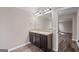 A bathroom with a double sink vanity, large mirror, and neutral wall color at 475 Louise Way, Locust Grove, GA 30248