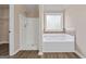 Bathroom featuring a tub with tiled surround, a separate shower, and neutral decor at 475 Louise Way, Locust Grove, GA 30248
