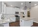 Beautiful kitchen with white cabinetry, stainless appliances, granite counters, and an island with pendant lighting at 475 Louise Way, Locust Grove, GA 30248